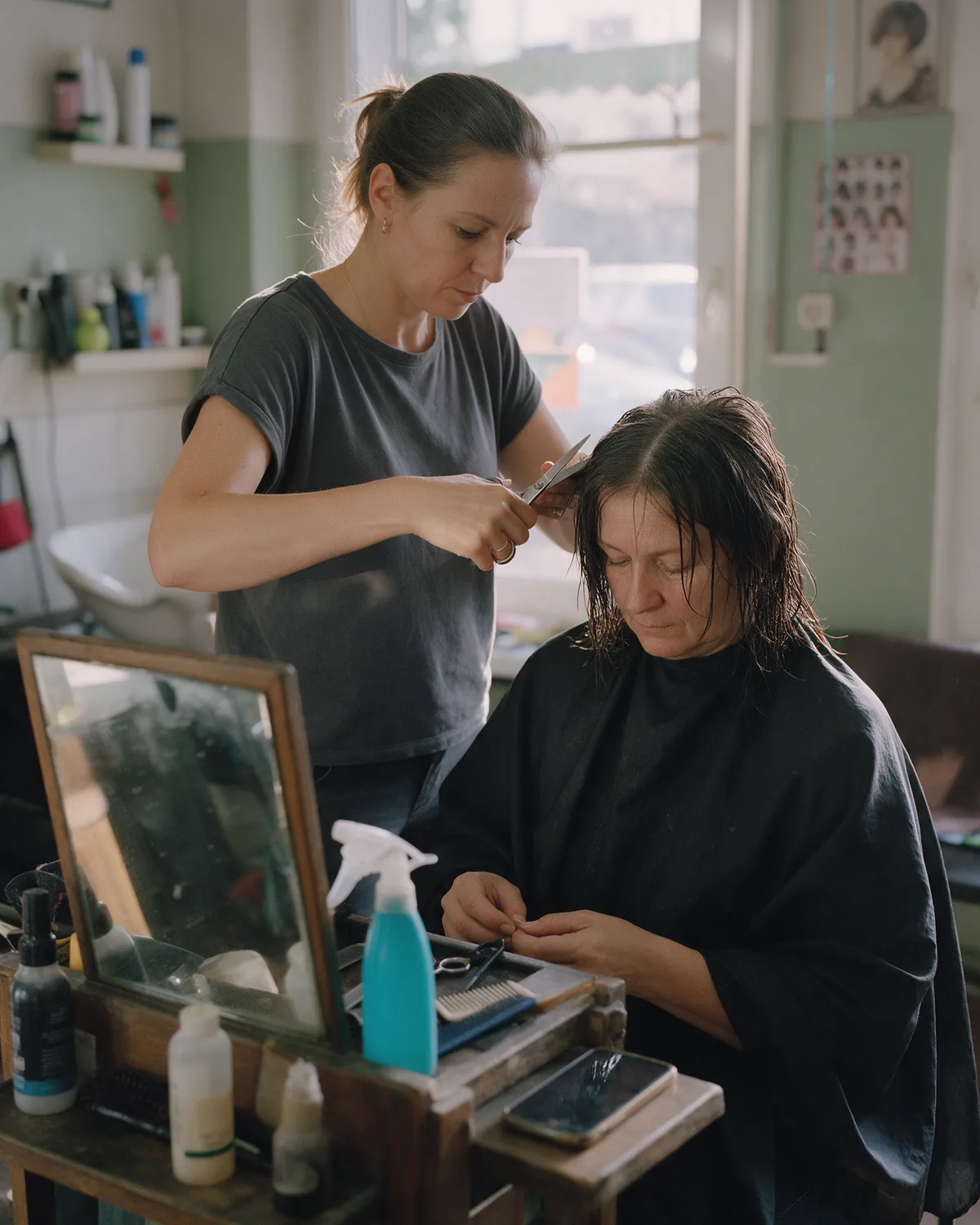 Fryzjerka strzyże klientkę w salonie